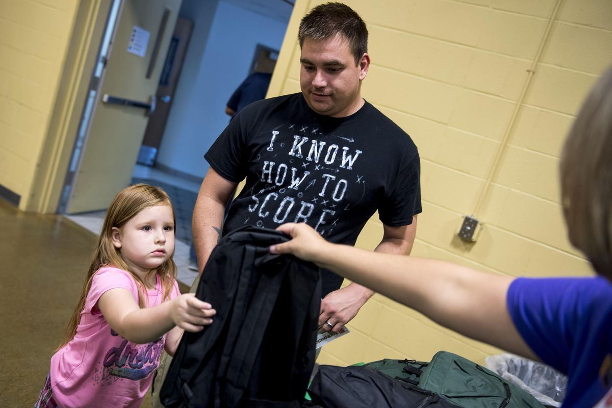 Kaylie Juarez, 5, with her dad Keith, receives her free backpack filed with school supplies at the The Salvation Army Resource Fair and Free Backpack Giveaway, Wed. Aug. 18, 2017, at the Salvation Army. Colin Mulvany/THE SPOKESMAN-REVIEW (Colin Mulvany / The Spokesman-Review)