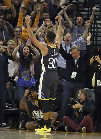 Golden State’s Stephen Curry celebrates with fans after scoring two of his season-high 49 points against the Boston Celtics on Saturday night in Oakland, California. (Ben Margot / Associated Press)