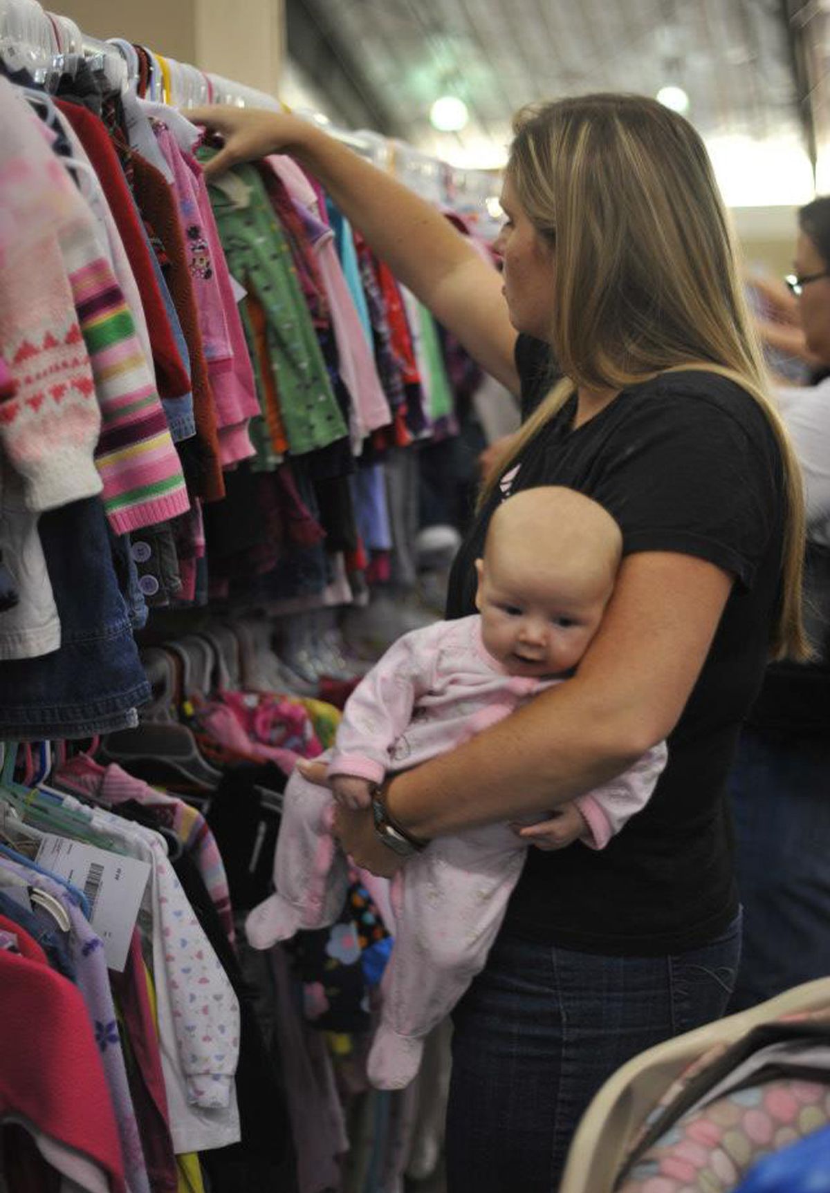 A shopper peruses baby clothing at a recent Just Between Friends consignment sale in Spokane. Thousands of shoppers are expected at this weekend’s sale at the Spokane County fairgrounds.