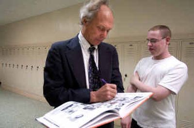 
West Valley High School Principal Cleve Penberthy signs sophomore Kevin Watts' yearbook in the hall of the high school. This is Penberthy's last year. 
 (Liz Kishimoto / The Spokesman-Review)