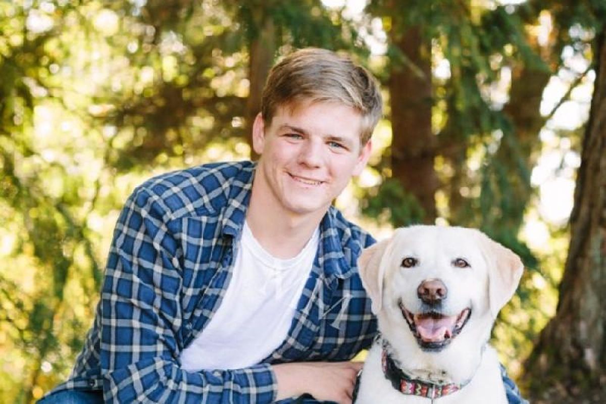 Washington State University freshman Matthew Gray poses with the family labrador, Ginger, in 2016. Gray, 19, spent weeks in a coma after falling out the window of his second-story dorm room in August 2017, and his father launched a campaign urging WSU to “fix the windows.” (Courtesy photo)