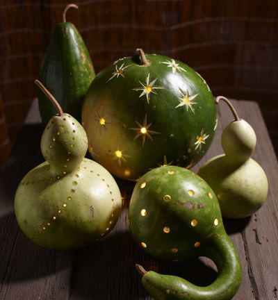 Better Homes and Gardens suggests drilling gourds and pumpkins with holes, then inserting battery-operated votives. (Associated Press)