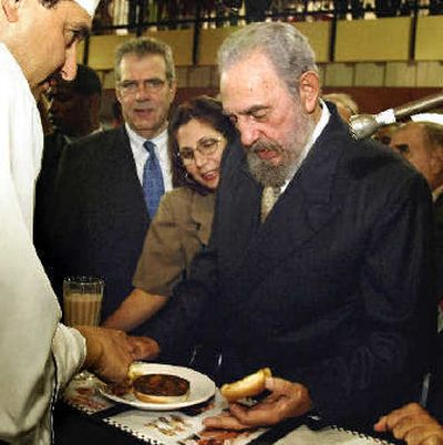 
Cuban President Fidel Castro lifts the bun of a hamburger during the U.S. agribusiness exhibition in 2002 in Havana. 
 (File/Associated Press / The Spokesman-Review)