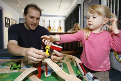 
Eban Schletter and 3-year-old Zoe McGaha-Schletter play with Thomas & Friends Wooden Railway toys Monday at Schletter's sound studio in Los Angeles as Schletter's wife, Kris McGaha, watches. Associated Press photos
 (Associated Press photos / The Spokesman-Review)