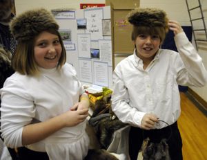 Sendal Hudson and Colton Thiede model raccoon hats that were worn during colonial times in North America. Fifth-graders at Opportunity Elementary School hosted their annual Sail America Expo on Tuesday, where they acted as travel agents and tried to convince parents and visitors to settle in their colony. (J. BART RAYNIAK)