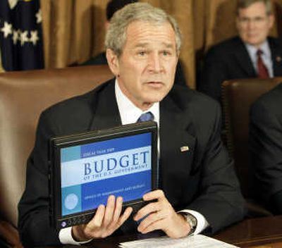 
President Bush holds a laptop showing the fiscal 2009 Federal Budget on Monday during a Cabinet meeting.
 (Associated Press / The Spokesman-Review)