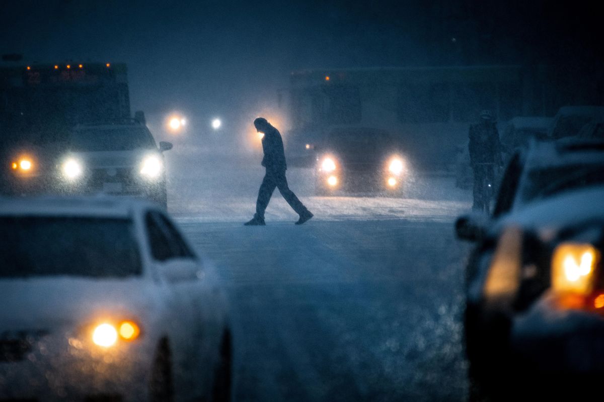 Durings Friday’s Snowstorm, a pedestrian crosses Sprqgue Avenue, at Post Street, in downtown Spokane, Wash. (Colin Mulvany / The Spokesman-Review)