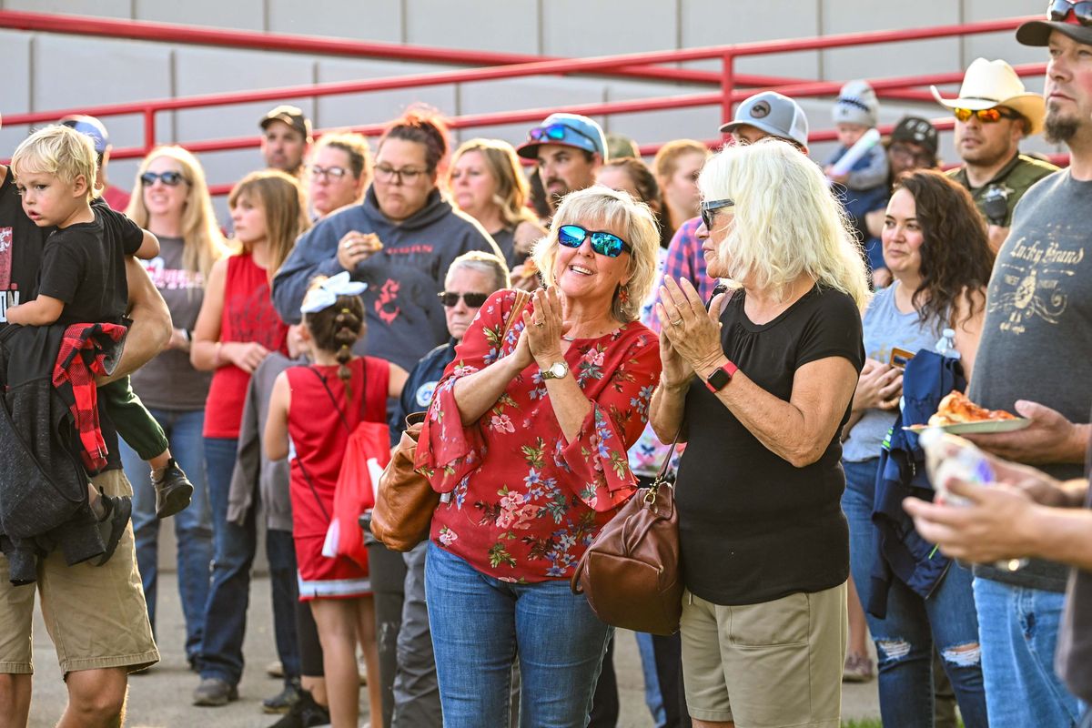 Diane Cortez, center, and Elaine Vandervert show their support for Elk fire victims Friday during a gathering at the Rise as One event at Riverside High School. Cortez said she live only 3 miles from the fire and Vandervert has lived in the community for 49 years. They said they came to donate money.  (DAN PELLE/THE SPOKESMAN-REVIEW)