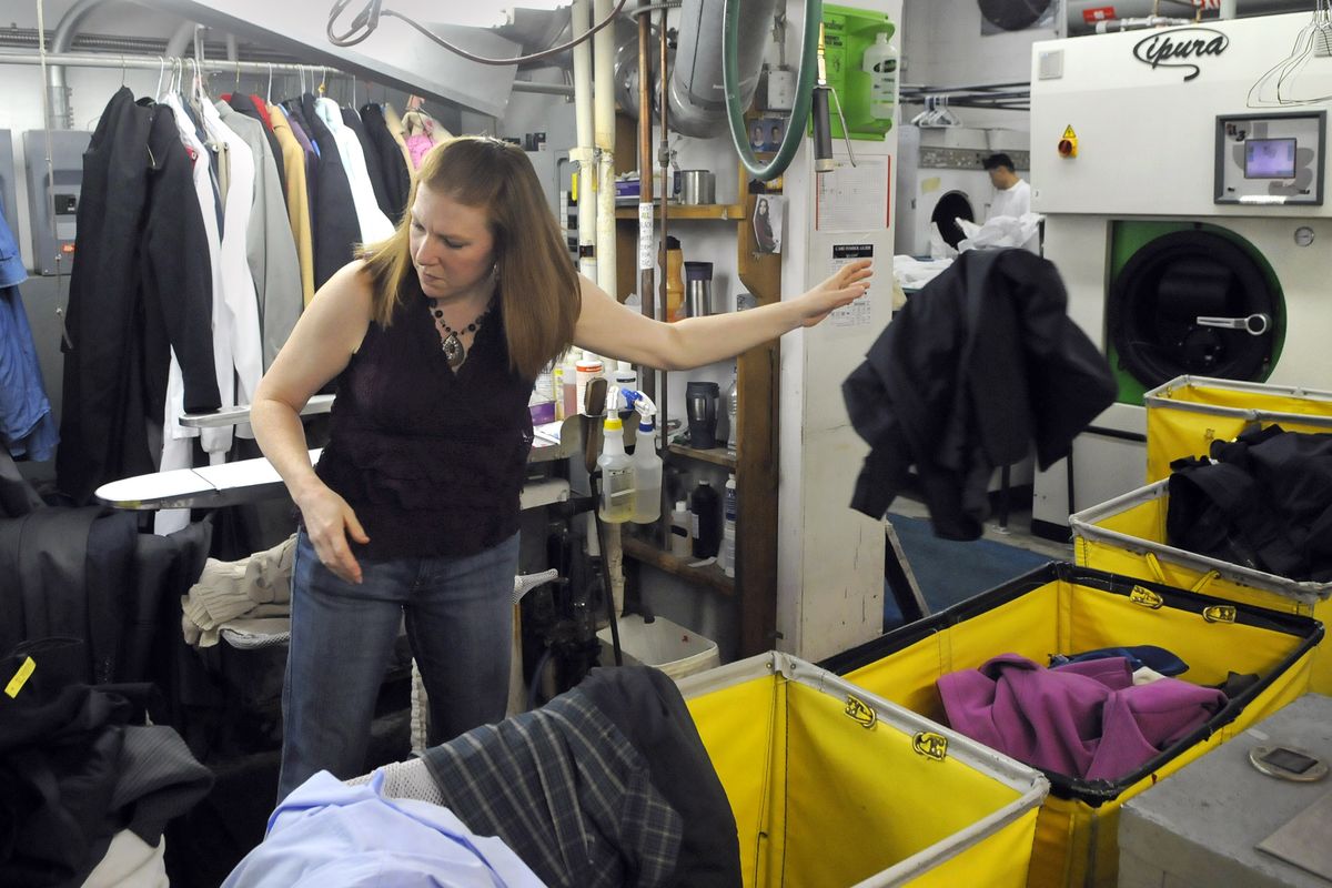 Valerie Busch, production manager at Beacon Cleaners, sorts dark-colored laundry into bins on Monday. The clothes would then be loaded into enviromentally friendly dry cleaning machines. (Dan Pelle)