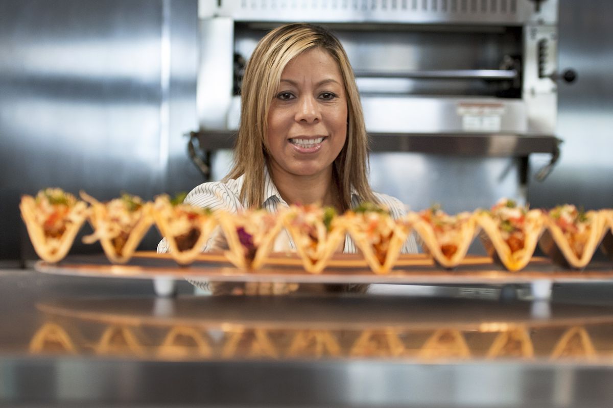 Mayra De Leon of De Leon’s Foods serves a platter of tacos at their new Taco and Bar restaurant on North Hamilton Street in Spokane on Thursday, Aug. 8, 2019.  (Kathy Plonka/The Spokesman-Review)