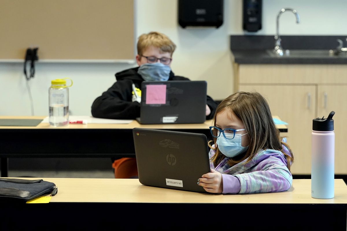 FILE - In this Feb. 2, 2021, file photo, students wear masks as they work in a fourth-grade classroom, at Elk Ridge Elementary School in Buckley, Wash. Amid mounting tensions about school reopening, the Centers for Disease Control and Prevention planned to release long-awaited guidance Friday, Feb. 12, 2021, on what measures are needed to get children back into the classroom during the pandemic.  (Ted S. Warren)