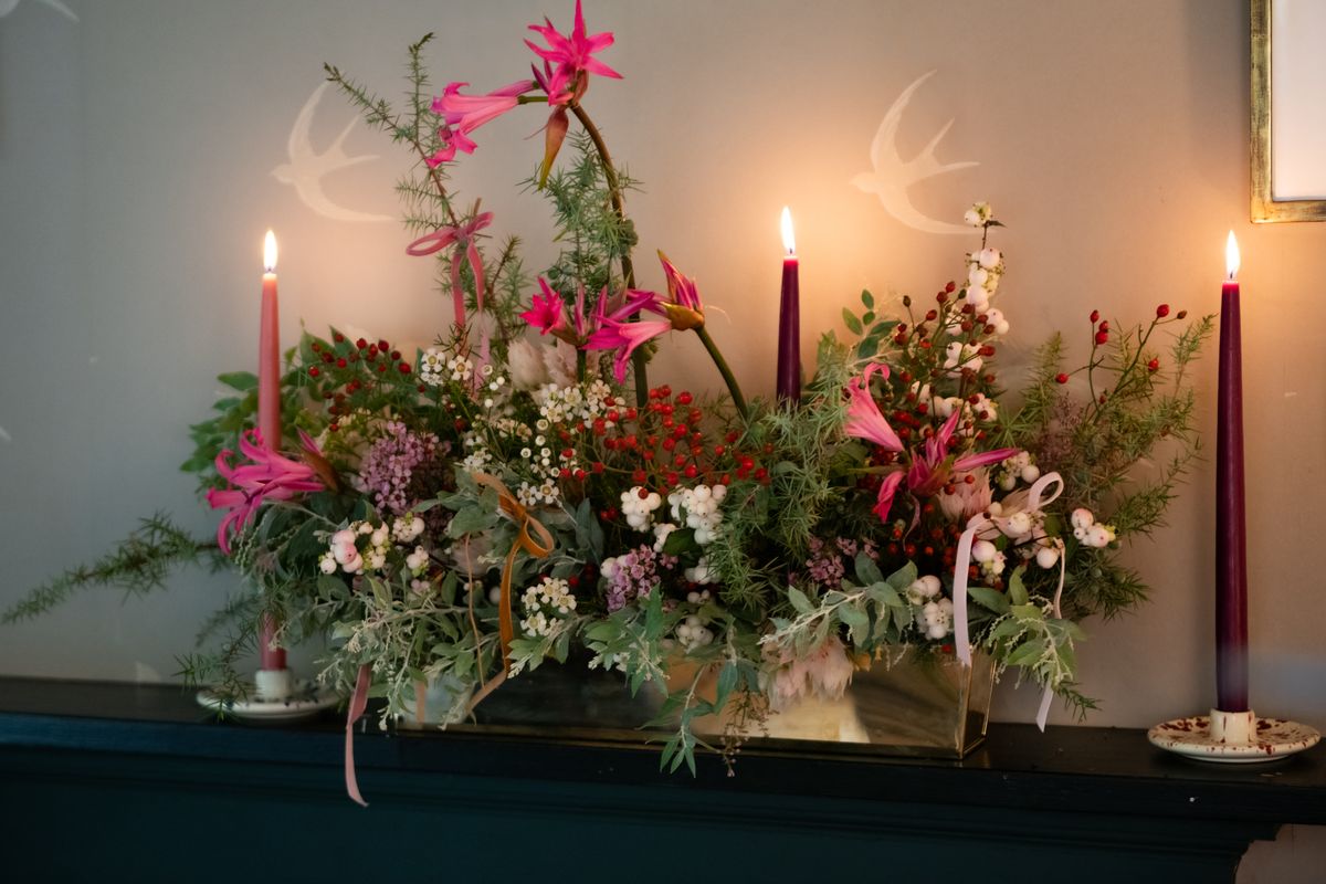 Here, Willow Crossley combines flowers and greenery with taper candles for a beautiful holiday decoration.  (Courtesy of Genevieve Stevenson)