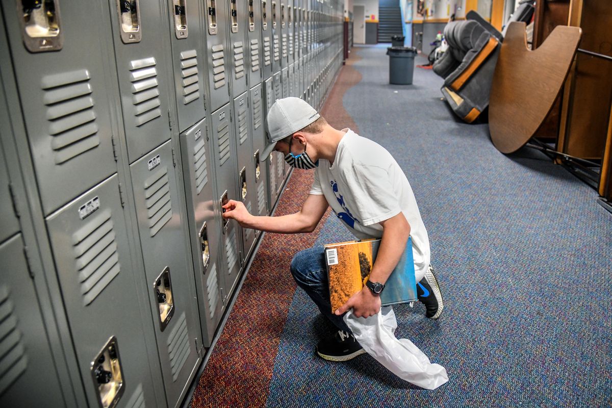 Chase Middle School student Porter Richardson, 13, remembers his combination numbers to open and clean out his locker on June 11. Spokane Public Schools launched a day program to offer families a supervised, safe place to do remote school work, but officials say the cost has meant few students from low-income families have enrolled.  (DAN PELLE/The Spokesman-Review)