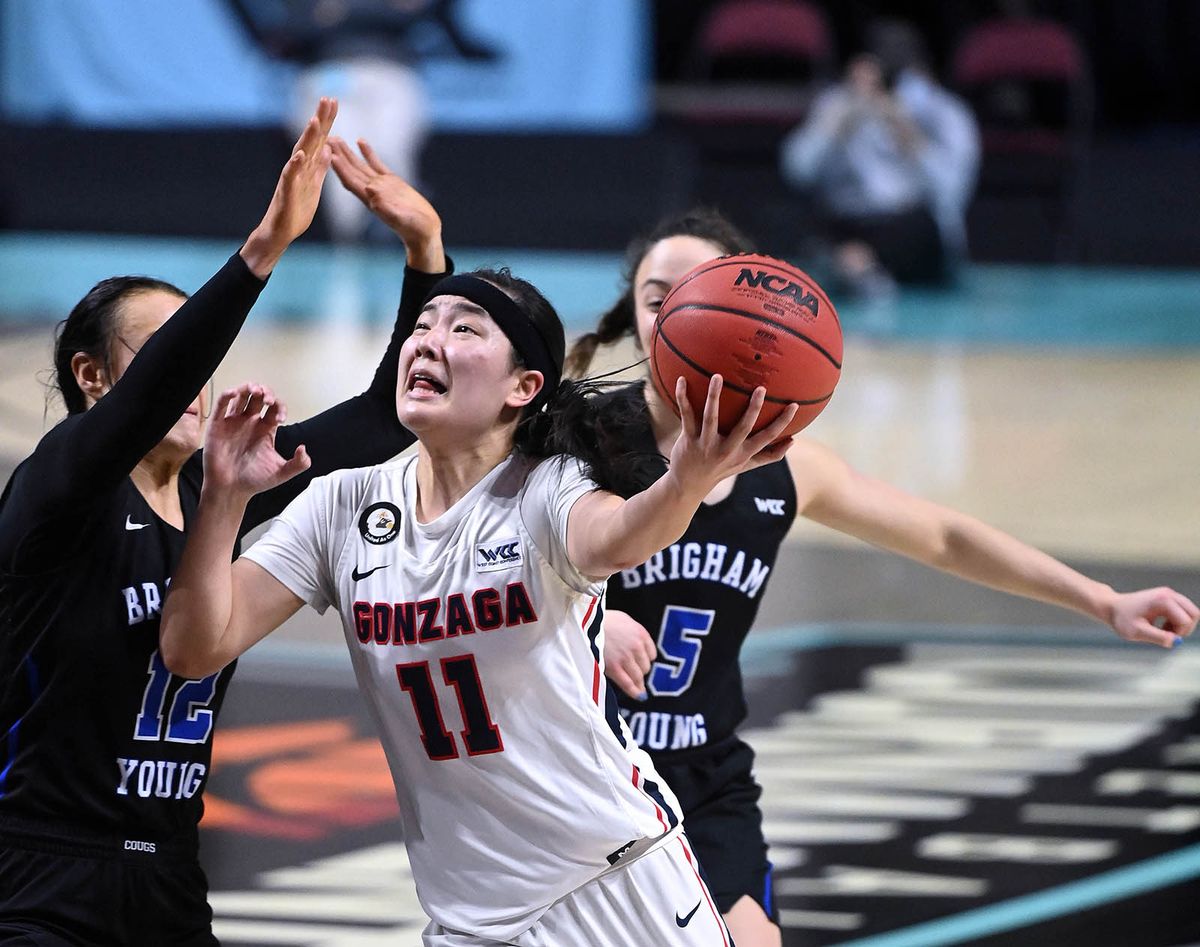 Gonzaga guard Kayleigh Truong (11) eyes the basket as BYU forward Lauren Gustin (12) and BYU guard Maria Albiero (5) defend during the first half of a West Coast Conference Tournament final NCAA college basketball game, Tuesday, March 9, 2021, at the Orleans Arena in Las Vegas.  (COLIN MULVANY/THE SPOKESMAN-REVIEW)
