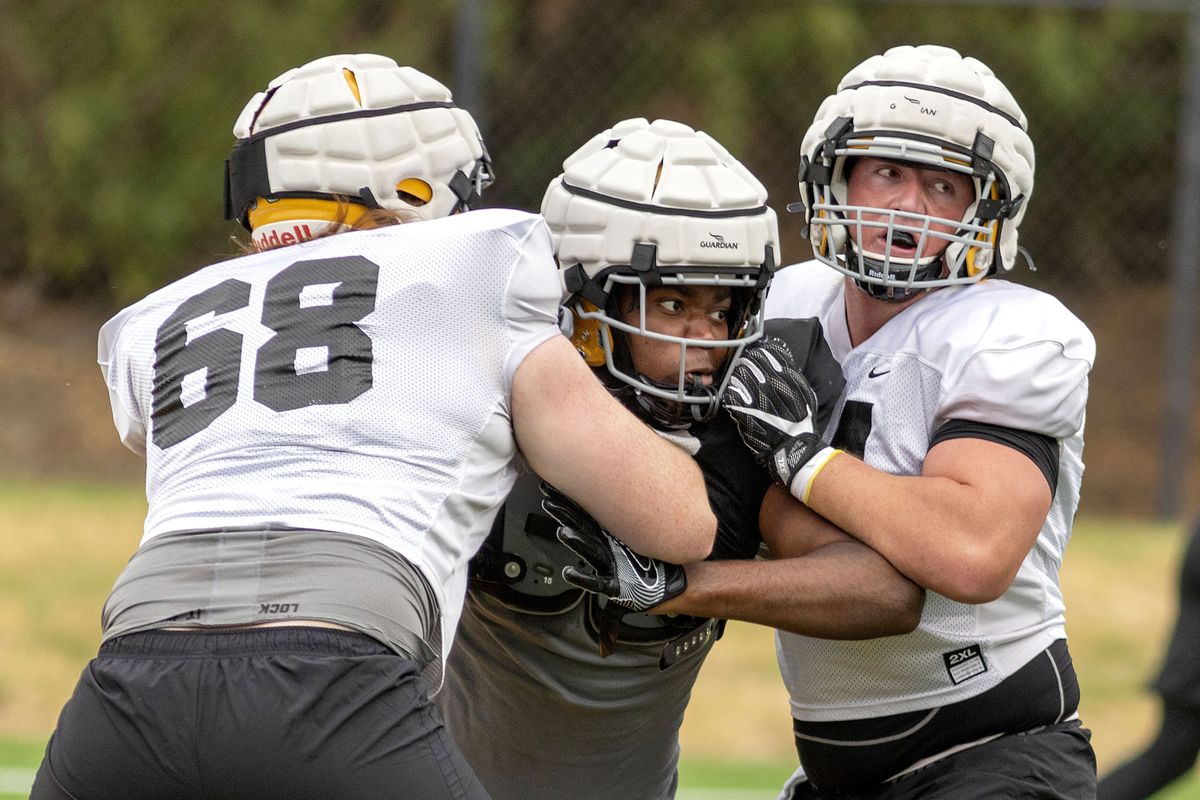 Idaho offensive linemen Logan Floyd, right, and Seth Carnahan, left, block a defender (92) during a recent practice.  (Geoff Crimmins/For The Spokesman-Review)