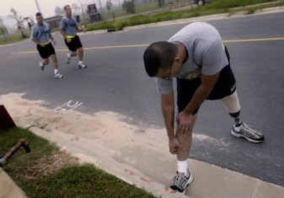 
Spc. George Perez, of the 1st Brigade of the 504th Parachute Infantry Regiment, stretches his legs during PT at Fort Bragg, N.C. Perez, one of at least four amputees from the elite 82nd Airborne Division to re-enlist, intends to show a medical board he can run an eight-minute mile, jump out of airplanes and pass all the other paratrooper tests that will allow him to go with his regiment to Afghanistan sometime next year. 
 (File/Associated Press / The Spokesman-Review)