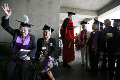 
Takako Yoda gives her tassel a playful flip while waiting to enter the University of Washington's Kane Hall for a ceremony Sunday.  With her is Miyo Shantaku, and at center is Todd Mildon, the university's registrar. Associated Press
 (Associated Press / The Spokesman-Review)