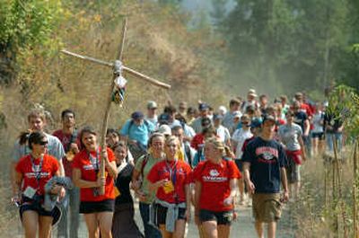 
Jenny Cornutt, a freshman at Gonzaga University, carries the rustic cross, leading walkers on the 38th annual pilgrimage Saturday to the Cataldo mission. About 200 students and staff retraced the steps of early Jesuit missionaries,  hiking about nine miles through the hills along the Coeur d'Alene River to the mission. 
 (Photos by JESSE TINSLEY / The Spokesman-Review)