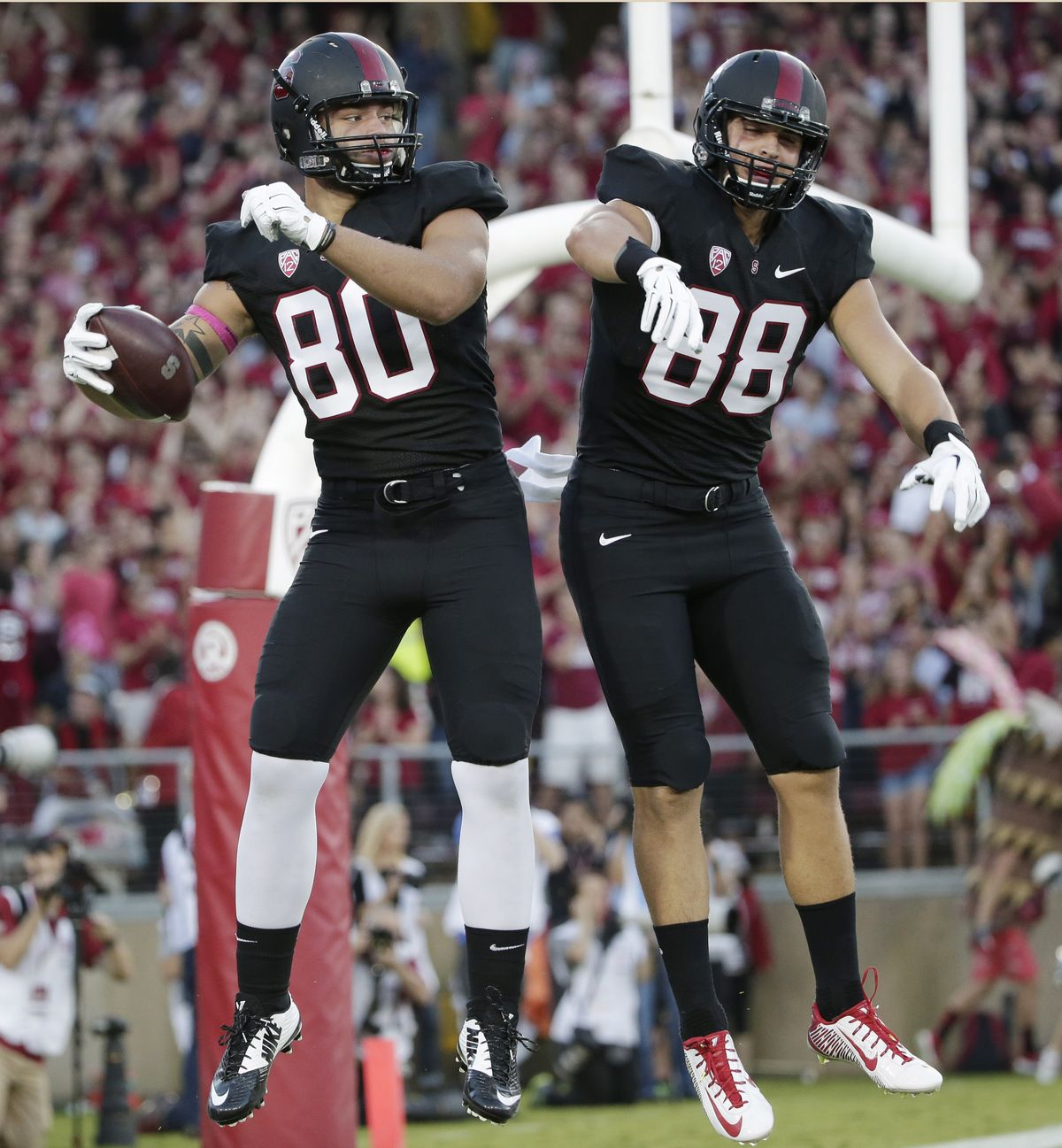 Stanford tight end Eric Cotton, left, celebrates his touchdown reception with teammate Greg Taboada during the first half of an NCAA college football game on Friday, Oct. 10, 2014, in Stanford, Calif. (Marcio Sanchez / Associated Press)