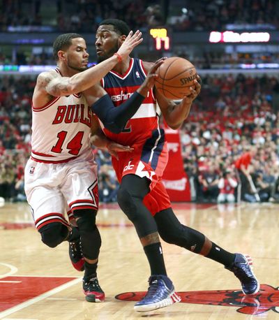 Wizards guard John Wall drives on Bulls’ D.J. Augustin during Tuesday’s series-clinching win. Wall had a team-leading 24 points. (Associated Press)