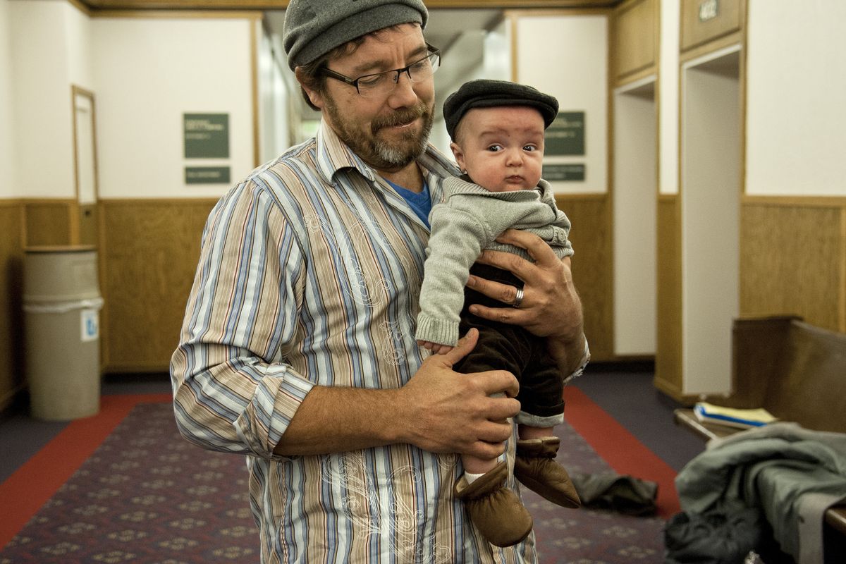 Buddy White waits outside the courtroom of Judge Linda Tompkins at the Spokane County Courthouse with 2-month-old Eliam on Friday. White, his wife, Tammie, and other family members adopted the child in Tompkins’ courtroom on National Adoption Day. (Dan Pelle)
