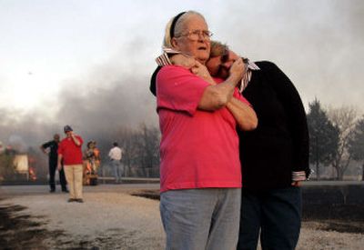
Bernice Alvarez, center, cups the face of her daughter, Gerrianne Patterson, as the two look at the remains of Alvarez's Arlington, Texas, home, which was destroyed by the wildfires raging across Texas and Oklahoma.
 (Associated Press / The Spokesman-Review)