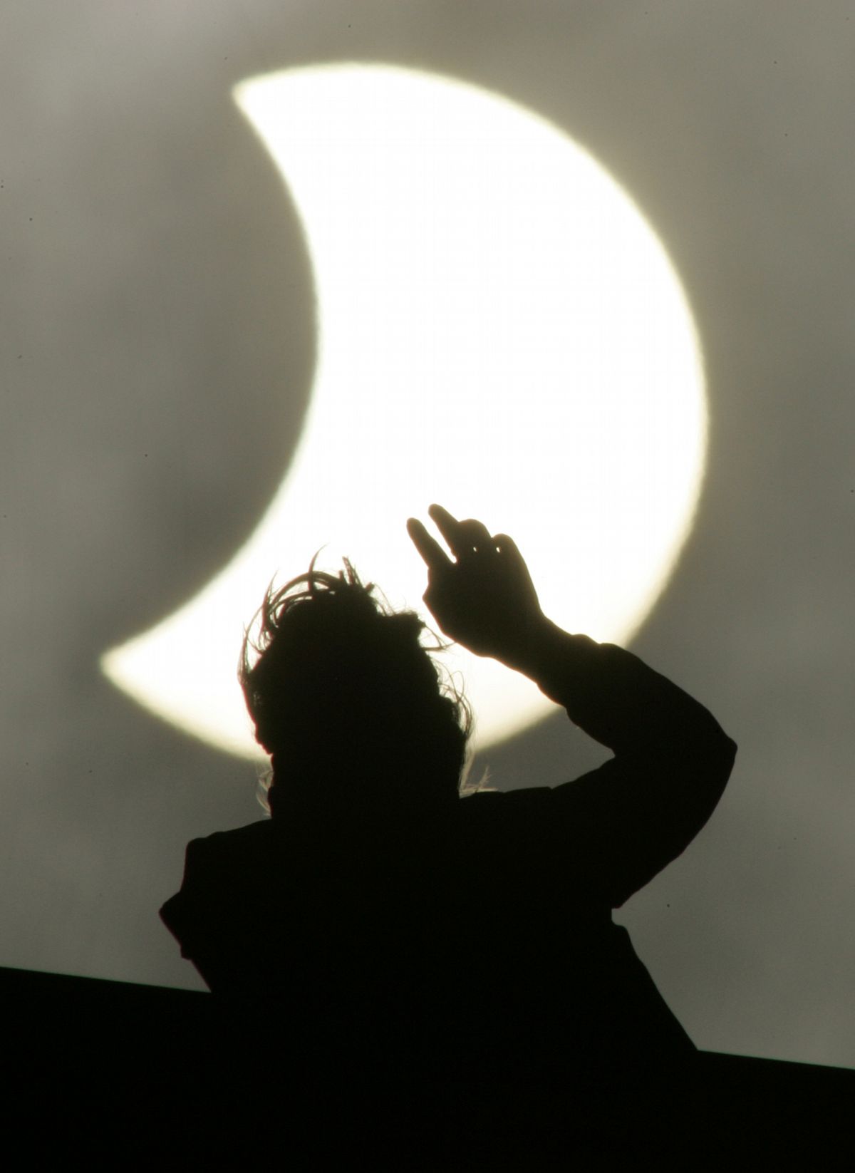 A woman looks at the moon partly covering the sun, during a partial solar eclipse Friday in St. Petersburg, Russia. Associated Press photos (Associated Press photos / The Spokesman-Review)