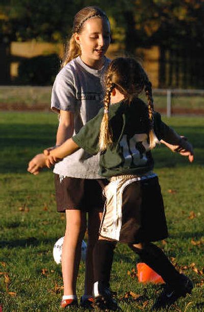 
Coach Megan Alger, left, helps out 4-year-old Brittney Stover with her jumping jacks at a soccer practice. 
 (Associated Press / The Spokesman-Review)