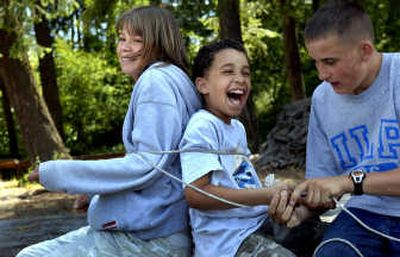 
From left, siblings Justin, 14, Beth, 16, and Matt, 15, skip rocks into Lake Coeur d'Alene. Justin and Beth live together but only see Matt once a year at camp.
 (Photos by Kathy Plonka / The Spokesman-Review)