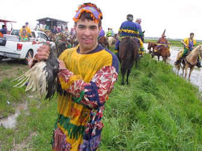 
A young reveler holds a chicken caught near a water-soaked field during the Courir de Mardi Gras celebration in Mamou, La.  McClatchy-Tribune
 (McClatchy-Tribune / The Spokesman-Review)