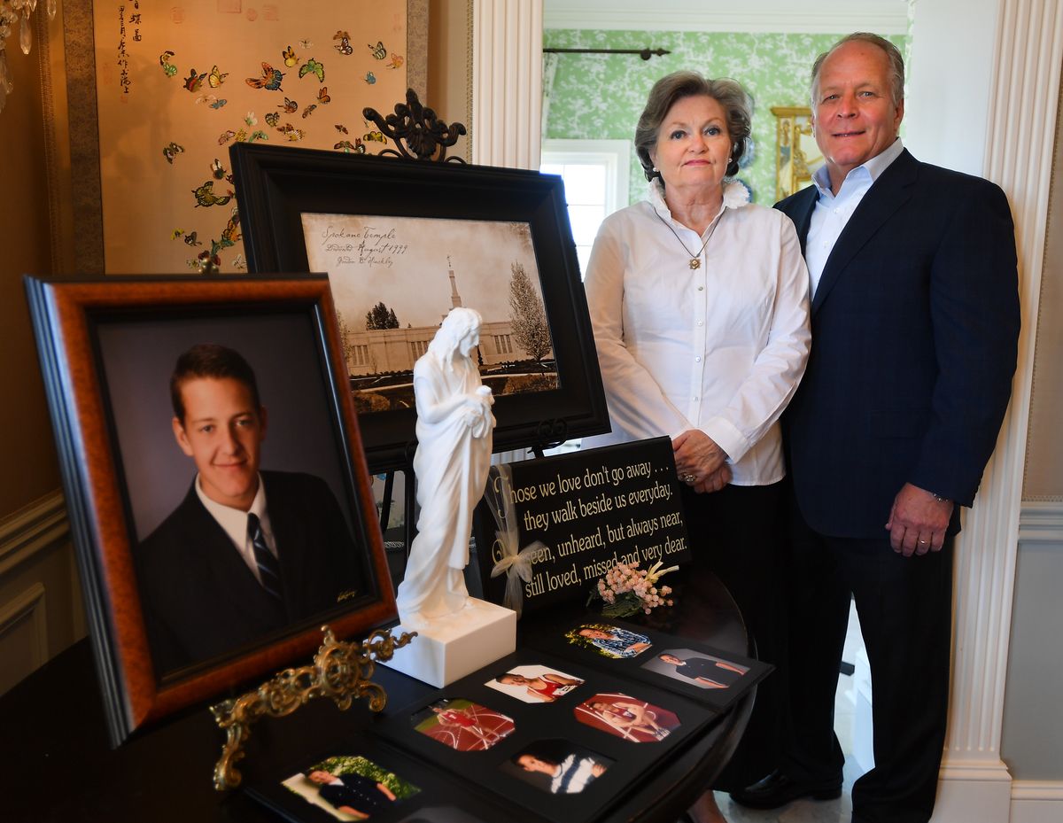 At their home in Spokane on Sept. 2, Ann and Paul Hawkins stand for a photo with images of their youngest son Tommy, who died at the age of 19 on Sept. 3, 2011, a few days before they were to move him to start college.  (Tyler Tjomsland/The Spokesman-Review)