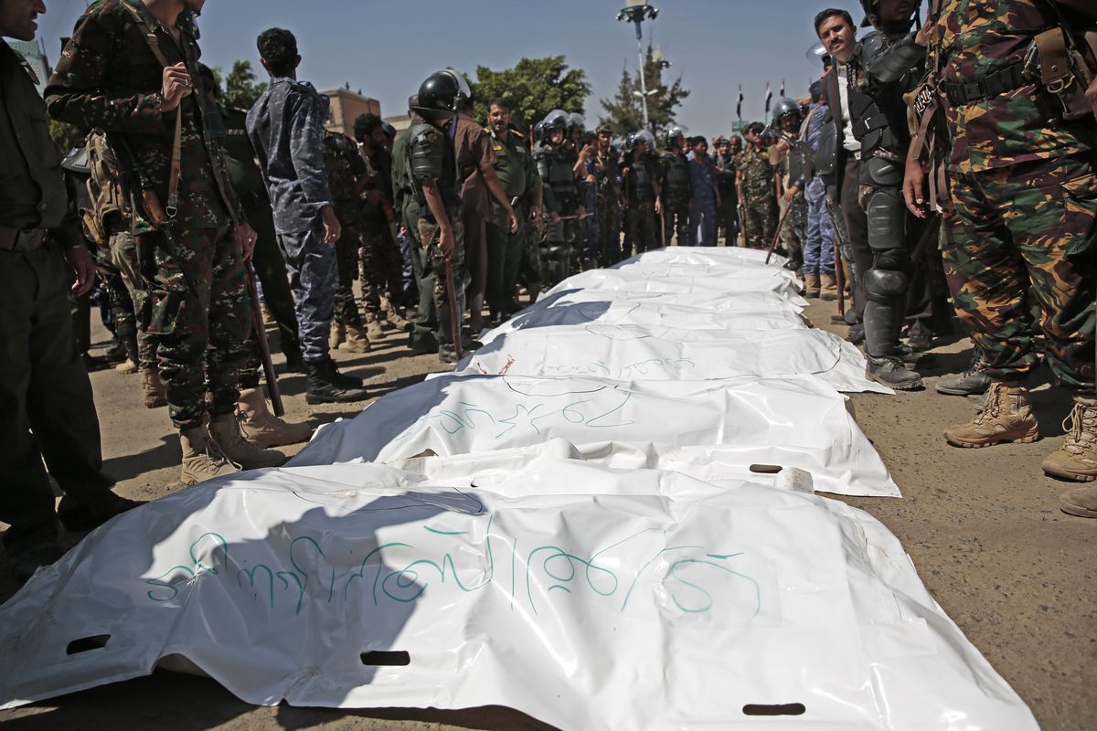 Police troopers stand around bags containing the bodies of nine men, convicted of involvement in the killing of a senior Houthi official Saleh al-Samad after their execution at Tahrir Square in Sanaa, Yemen Saturday, Sept. 18, 2021. Yemen