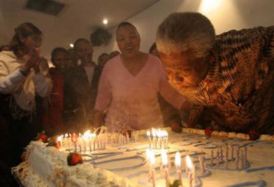 
Former South African President Nelson Mandela  blows out candles on a birthday cake presented to him by his staff on Monday, the eve of his 88th birthday.
 (Associated Press / The Spokesman-Review)