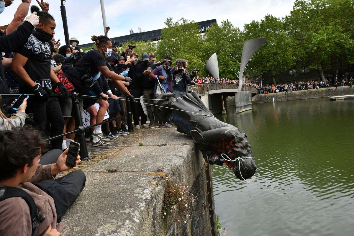 Protesters throw a statue of Edward Colston into the Bristol harbour during a Black Lives Matter rally on June 7, 2020, in Bristol, England. Four anti-racism demonstrators were cleared Wednesday of criminal damage in the toppling of the statue of the 17th-century slave trader.  (Ben Birchall)