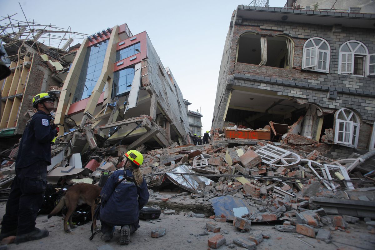 USAID rescue workers inspect collapsed buildings after a quake in Kathmandu, Nepal, on Tuesday. (Associated Press)