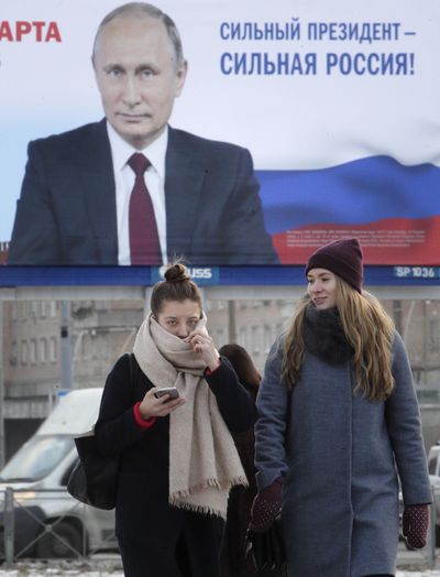 People walk past a pre-election poster depicting Russian President Vladimir Putin in St.Petersburg, Russia, Monday, Jan. 15, 2018. (Dmitri Lovetsky / Associated Press)
