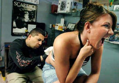 
Washington State freshman Alexa Smith, 18, yelps in pain as tattoo artist Robby Slaughter adds a turtle to her lower back at Mystical Tattoo in Pullman on Saturday. Smith was there with her mother. 
 (Joe Barrentine / The Spokesman-Review)