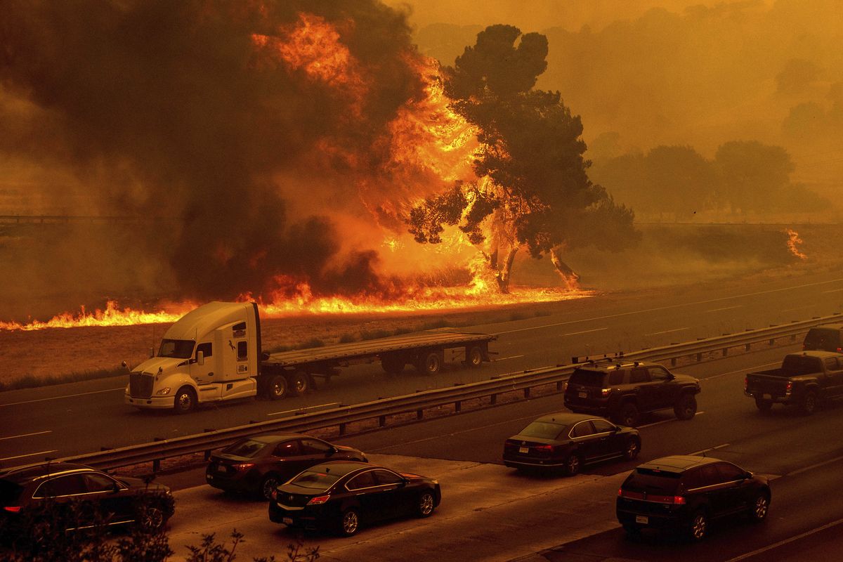 Flames from the LNU Lightning Complex fires jump Interstate 80 in Vacaville, Calif., Wednesday, Aug. 19, 2020. The highway was closed in both directions shortly afterward. Fire crews across the region scrambled to contain dozens of wildfires sparked by lightning strikes as a statewide heat wave continues.   (Noah Berger)