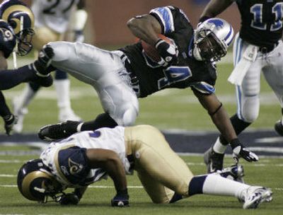 
Lions running back Kevin Jones (34) falls over Rams cornerback Terry Fair during the first quarter at Ford Field Monday in a 37-13 St. Louis victory. 
 (Associated Press / The Spokesman-Review)