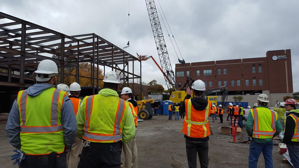 Workers on a Providence and Fairfax Behavioral Health psychiatric hospital on West Fifth Avenue watch as the final beam for the structure is raised into place on Oct. 20, 2017. (Rachel Alexander / The Spokesman-Review)