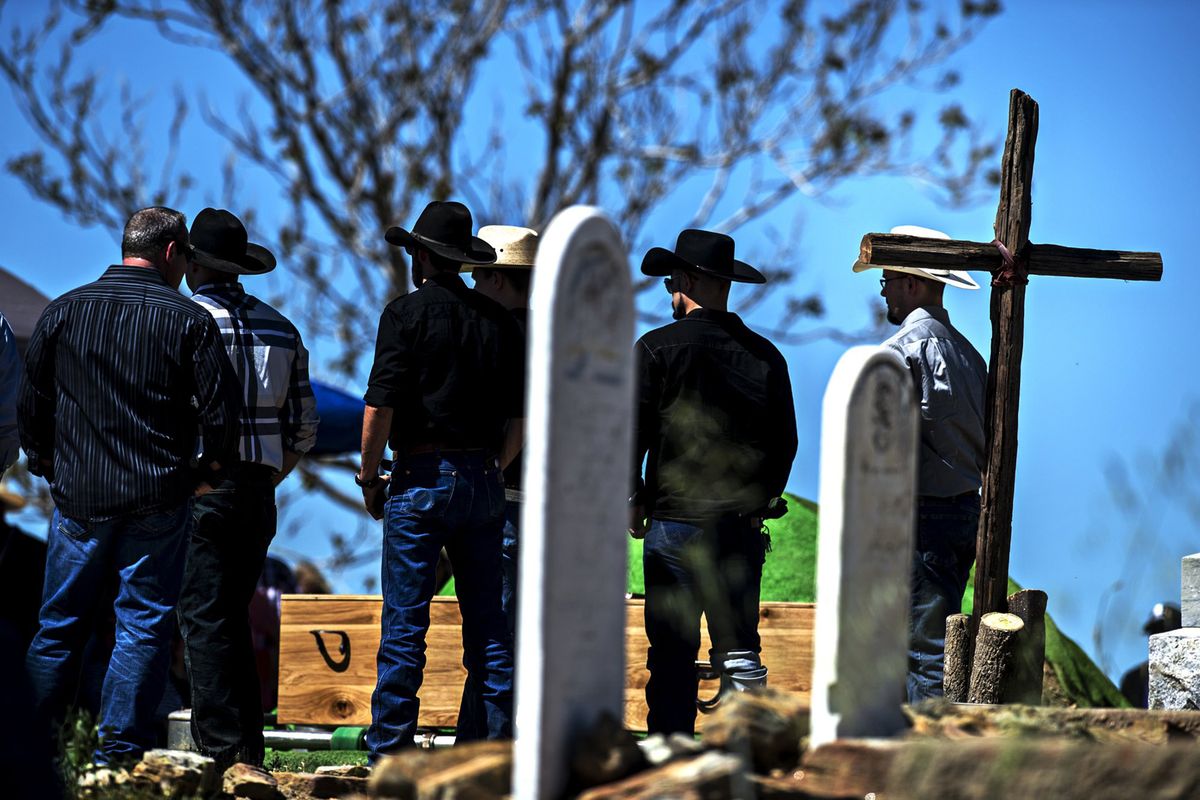 A wooden cross stands near the burial site during the funeral for Bob Wood at St. Catherine’s Catholic Church on March 27 in Hornitos, California.