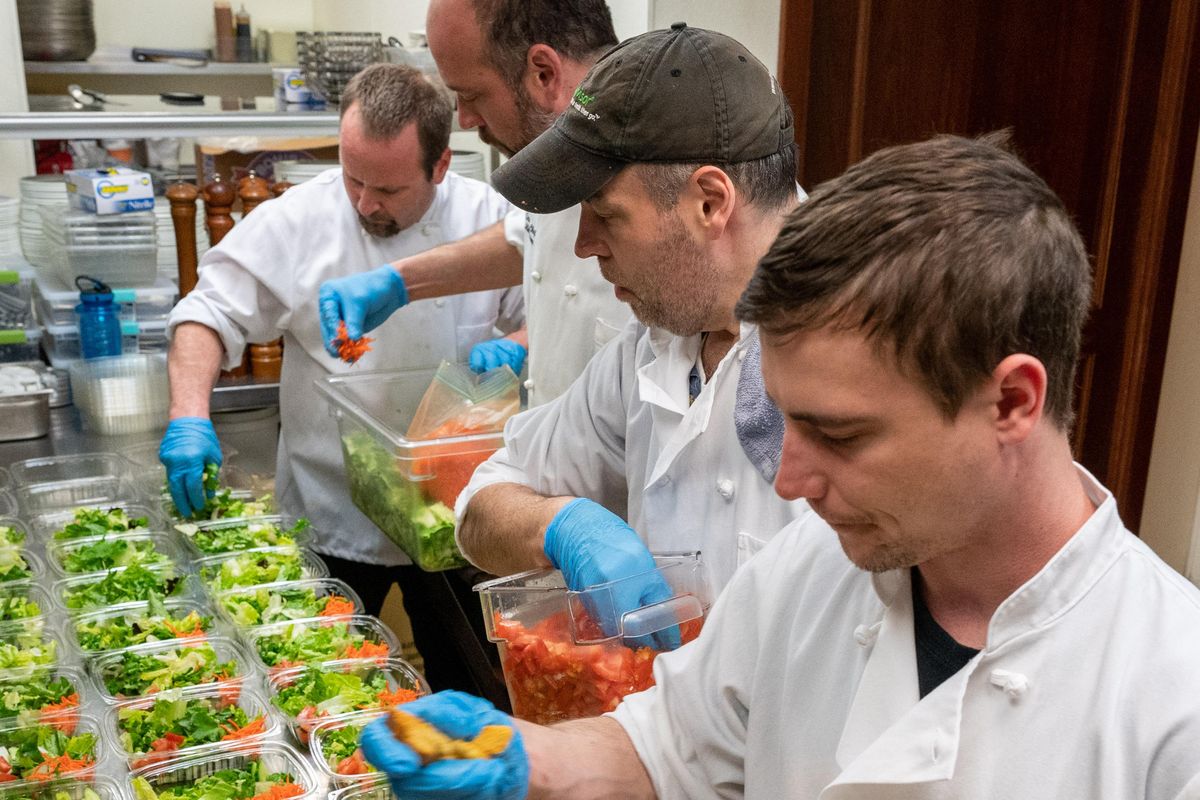Churchill’s Steakhouse kitchen staff, front to back, Jake Young, Robert Clark, executive chef Mike Peirone and Kalani Martin prepare salads for their employees who were laid off due to coronavirus closures. (Colin Mulvany / The Spokesman-Review)