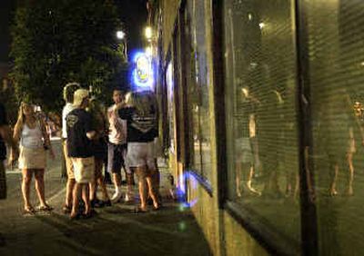 
A group of people argue outside The Big Easy on Friday night.  
 (Jed Conklin / The Spokesman-Review)