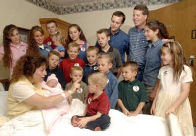 
In this Aug. 2 photo, Michelle Duggar is surrounded by her children and husband Jim Bob, third from right, after the birth of her 17th child in Rogers, Ark. Michelle is pregnant again. Associated Press
 (FILE Associated Press / The Spokesman-Review)
