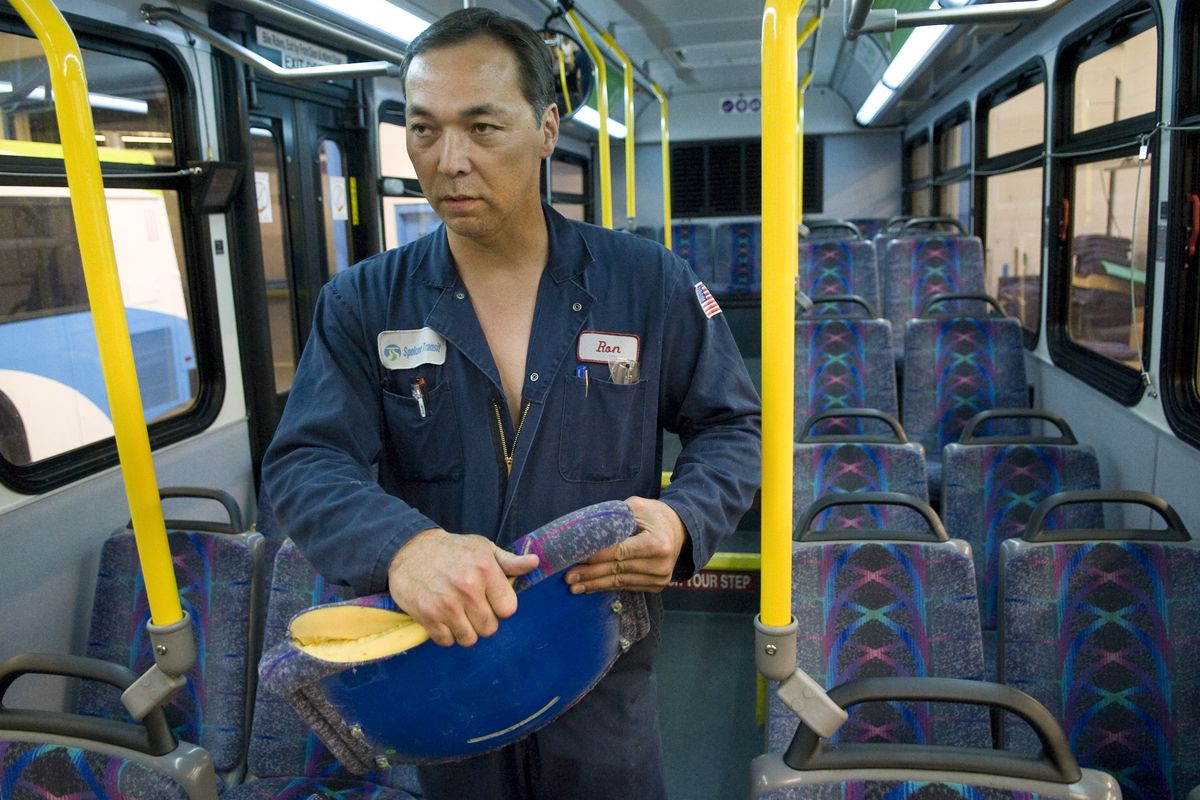STA mechanic Ron Scouton removes a vandalized seat cushion from a bus last week.  More than 100 seat cushions have been slashed. (Colin Mulvany / The Spokesman-Review)