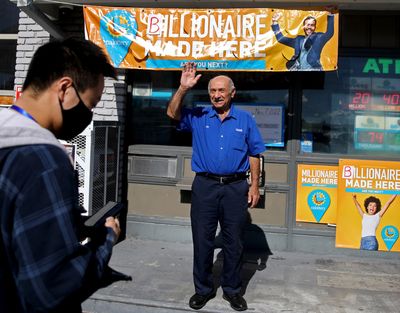 Joseph Chahayed, who sold the record-breaking Powerball ticket worth more than $2 billion, waves to a customer Nov. 9 at his Altadena gas station.    (Gary Coronado/Los Angeles Times/TNS)