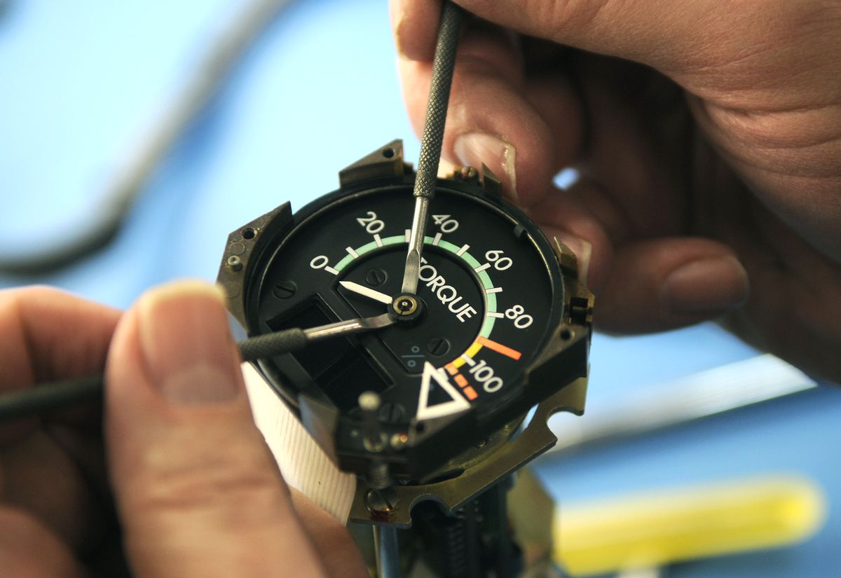 Howard Pumroy of Absolute Aviation removes the hands on a torque instrument from a prop plane. (Dan Pelle / The Spokesman-Review)