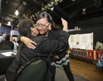 Yufna Soldier Wolf, left, of the Northern Arapaho is hugged by Marcida Eagle Bear on Tuesday, after her presentation to the Army representatives on the Rosebud Reservation. (Charles Fox / Associated Press)