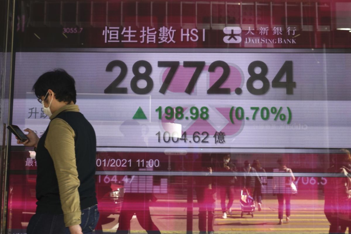 A woman walks past a bank’s electronic board showing the Hong Kong share index at the Hong Kong Stock Exchange on Monday.  (Vincent Yu/Associated Press)