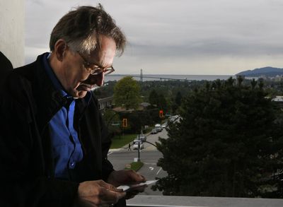 From a library terrace overlooking North Vancouver, B.C., near his home, Michael Barber looks at a photo of his son, Jonathan, 24, killed by a gunman who mistook him for a gang associate. Los Angeles Times (Don Bartletti Los Angeles Times / The Spokesman-Review)